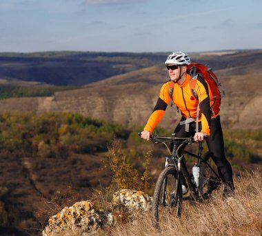 Genç bisikletçi dağ bisikleti dağ ile güzel manzara karşı yaz kayalık izinde ile standları.