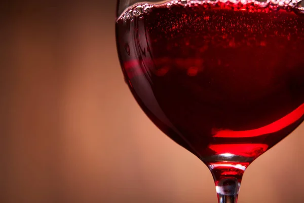 Verre à vin élégant et fragile de vin rouge savoureux sur fond de bois brun close-up . — Photo