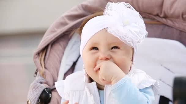 Close-up sorrindo bebê menina sentado no carrinho — Vídeo de Stock