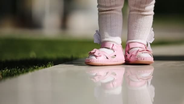 Close-up da linda bebê-menina de pé no parque no dia da luz do sol . — Vídeo de Stock