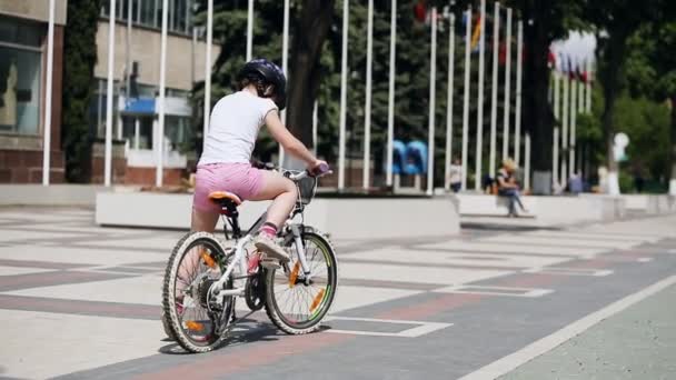 Bakifrån av den lilla flickan på cykel i sommar park i sunshine dagen. — Stockvideo