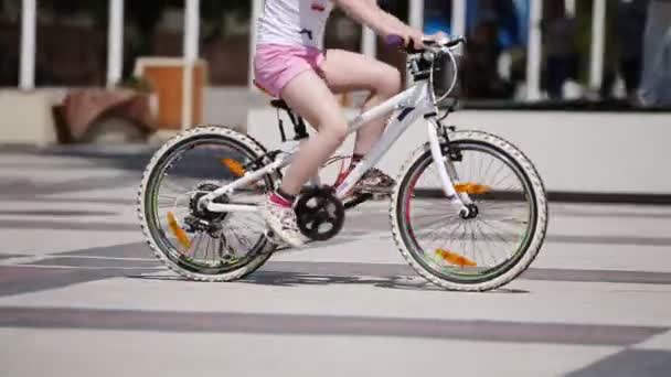 Happy little girl riding a bicycle in the city park at summer sunshine day. — Stock Video