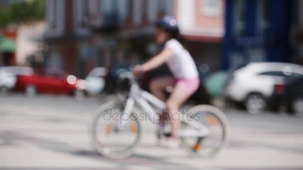 Lycklig liten flicka rider en cykel i stadsparken på sunshine sommardag. — Stockvideo