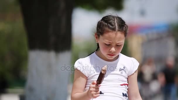 Primer plano de linda niña comiendo helado en el parque en el sol día de verano . — Vídeos de Stock