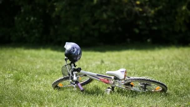 Menina bonito corre com flores no prado para seu bicyclein o dia de sol . — Vídeo de Stock