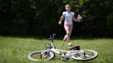 Sevimli kız çiçeklerle çayır on onun bicyclein için güneş gün çalışır.