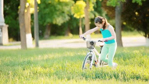 Felice bambino in sella a una bicicletta nel parco della città in estate giorno caldo . — Video Stock