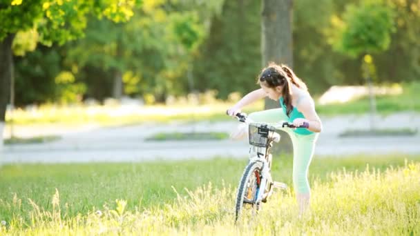 Счастливый ребенок катается на велосипеде в городском парке в летний теплый день . — стоковое видео