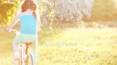Mutlu küçük kız yaz güneşli günde çayır on bir bisiklet sürme.