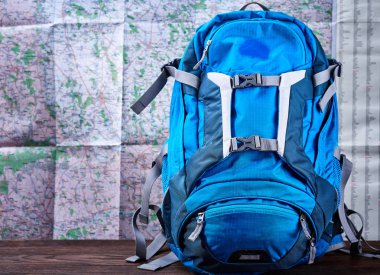 Harita arka plan karşı turist mavi sırt çantası.