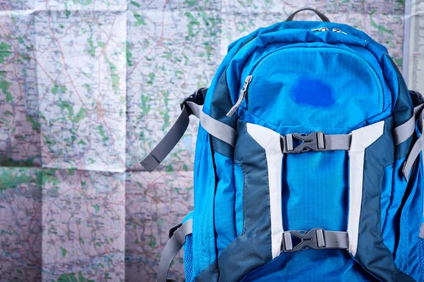 Туристичний синій рюкзак на фоні карти . — стокове фото