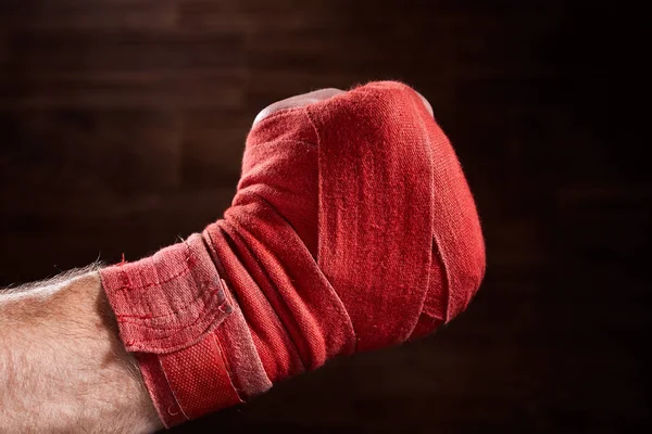 Zamknij się obraz pięść boksera z czerwonym bandaż na brązowym tle. — Zdjęcie stockowe