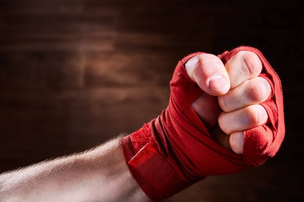 Görüntü bir boksör kahverengi zemin karşı kırmızı bandaj ile yumruk kadar kapatın. — Stok fotoğraf