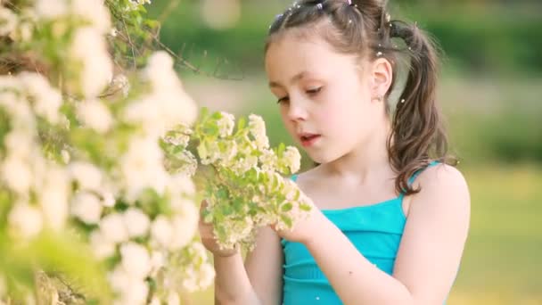 Primo piano di bambina gode l'odore dei fiori nel prato in estate . — Video Stock