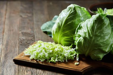 Ahşap arka plan üzerinde ahşap bir gemide taze Bahçe yeşil lahana dilimlenmiş.