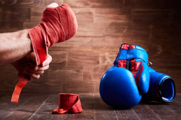 Крупный план рук молодого боксера, который мотает боксерские бинты и перчатки . — стоковое фото