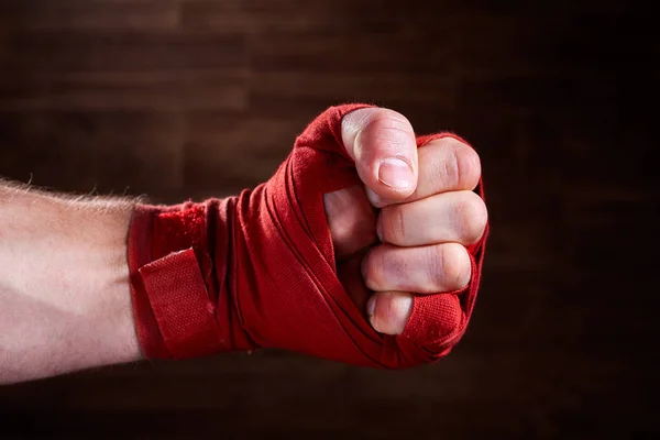 Görüntü bir boksör kahverengi zemin karşı kırmızı bandaj ile yumruk kadar kapatın. — Stok fotoğraf