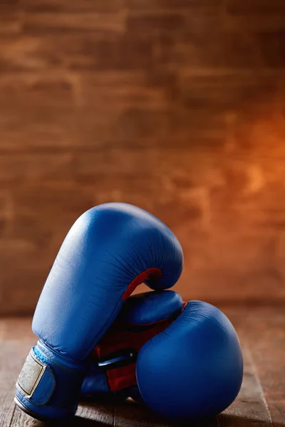 Par av två röda boxning handskar ligga på träbord mot trä bakgrund. — Stockfoto