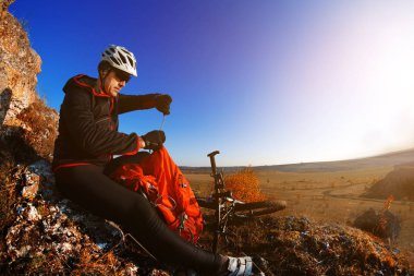 Görünüm üzerinde bisiklet yolunda bahar peyzaj bakarak Mountainbiker. Erkek binici Bisiklet gezisinde doğada dinlenme.