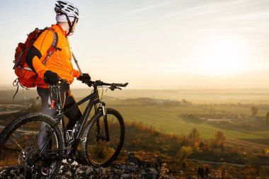 Bir kaya üzerinde bisiklet duran adam. Bahar doğa