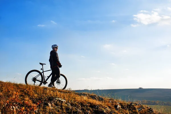 Rowerzysta w czarna kurtka jeżdżenie rower w dół wzgórza. Koncepcja Sport ekstremalny. Miejsca na tekst. — Zdjęcie stockowe