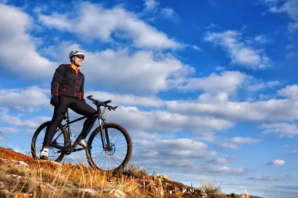 Ποδηλάτης μαύρο σακάκι ιππασίας το ποδήλατο κάτω λόφο. Extreme Sport έννοια. Χώρο για το κείμενο. — Φωτογραφία Αρχείου