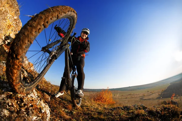 Low angle view of cyclist riding mountain bike on rocky trail at sunrise — Stock Photo, Image