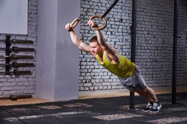 Duvara karşı spor salonunda genç sporcu ile jimnastik egzersiz eşofman yüzük.