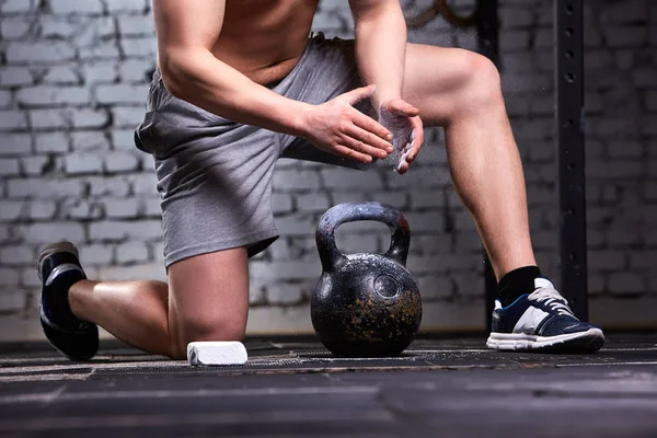 Photo of young athlete man while getting ready for crossfit training with dumbbells against brick wall. — Stock Photo, Image