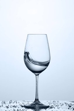 Bardağı taze ve şeffaf Su damlacıkları ışık arka plan ile cam üzerinde duran ile.