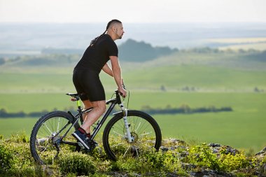 Güzel manzara arka plan üzerinde dağ bisikleti ile ayakta bisikletçi.
