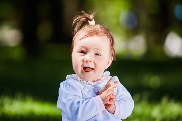 Detail v létě portrét krásné baby Girl na trávníku v parku. — Stock fotografie