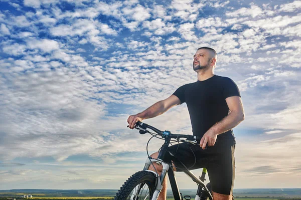 Крупный план велосипедиста против красивого голубого неба с облаками . — стоковое фото