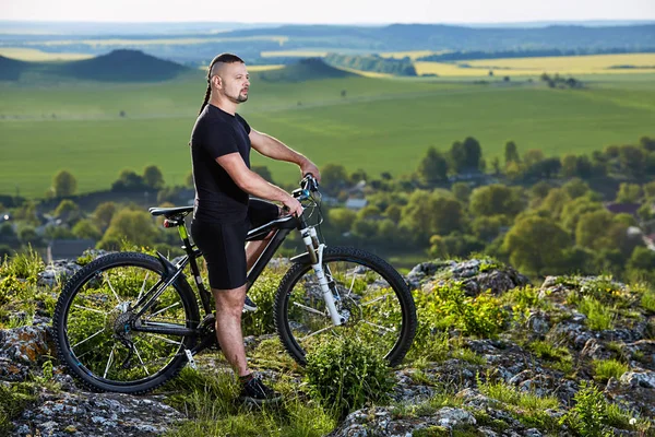 Cyclist standing with mountain bike on background of beautiful landscape. — Stock Photo, Image
