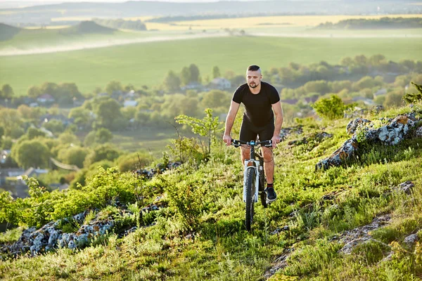 Junge Radfahrerin radelte auf steinigem Weg gegen schöne Landschaft. — Stockfoto