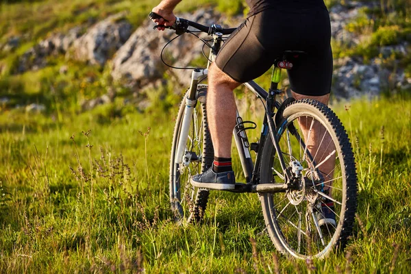 Μεγέθυνση λεπτομέρειας του ποδηλάτη πόδια άνδρα ιππασία ποδήλατο βουνού στο βραχώδες μονοπάτι. — Φωτογραφία Αρχείου