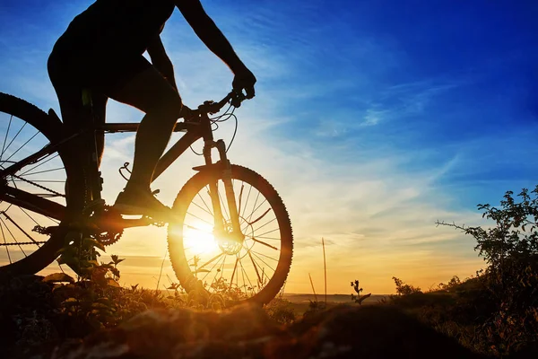 Close-up da silhueta do jovem ciclista no céu por do sol com nuvens . — Fotografia de Stock