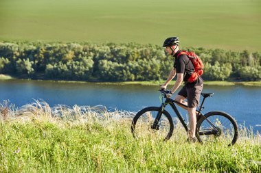 Çekici bisikletçi dağ bisikletçi nehir üzerinde yaz iz sürme.