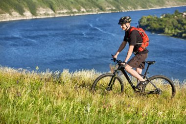 Çekici bisikletçi dağ bisikletçi nehir üzerinde yaz iz sürme.