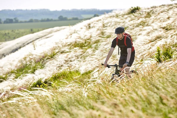 Lovaglás a kerékpáros, a gyönyörű nyári hegyi ösvényen vonzó kerékpáros. — Stock Fotó