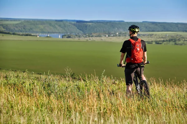 Dağ bisikleti karşı güzel manzara ile ayakta bisikletçi arkadan görünüş.