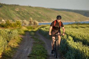 Genç bisikletçi dağ bisikletçi kırsal alanında yol gezintisi.