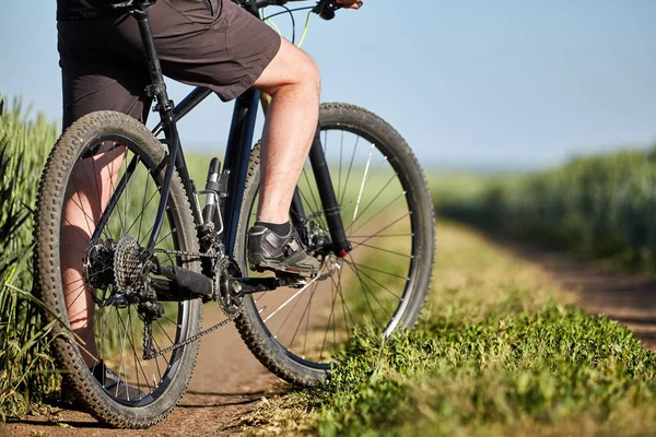 Primer plano de ciclista hombre piernas con bicicleta de montaña en el sendero al aire libre en el campo de verano . — Foto de Stock