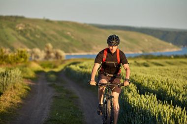 Genç bisikletçi dağ bisikletçi kırsal alanında yol gezintisi.