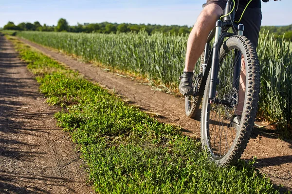 Fechar as pernas do ciclista homem com mountain bike em trilha ao ar livre no campo de verão . — Fotografia de Stock
