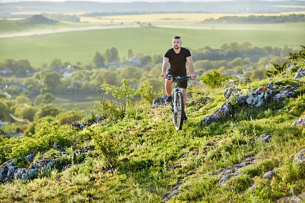 Young cyclist riding the bike on the rocky trail against beautiful landscape. — Stock Photo, Image