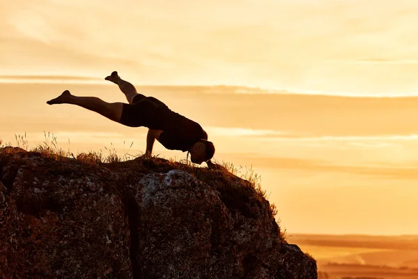 Silueta del hombre haciendo meditación de yoga contra el hermoso cielo con nubes . — Foto de Stock