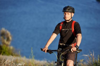 Çekici bisikletçi dağ bisikletçi nehir üzerinde yaz izinde ile ayakta.