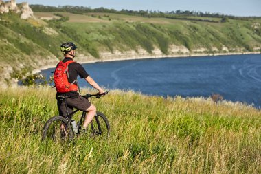 Arka bisikletçi manzarasına güzel yaz manzara karşı tepenin ayakta.