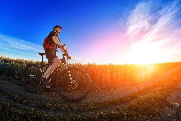 Szeroki kąt rowerzysta, stojąc na szlaku na polu przeciwko piękny krajobraz. — Zdjęcie stockowe